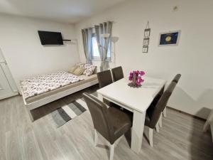 ein Wohnzimmer mit einem Tisch, Stühlen und einem Sofa in der Unterkunft Guesthouse Ella in Slunj