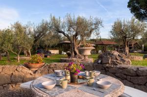 a table with cups and flowers on a stone wall at Roman Oasis Villa in Ciampino +44 photos