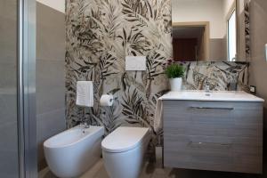 a bathroom with a toilet and a sink at Tarsis Guest House in Baunei