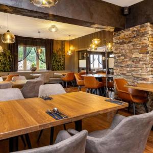 a restaurant with tables and chairs and a brick wall at GARDEN Restaurant & Pension in Pardubice