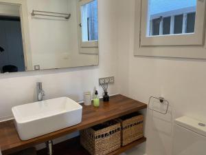 een badkamer met een witte wastafel en een spiegel bij Apartamento en Vilanova i la Geltrú in Vilanova i la Geltrú