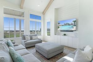 a living room with two couches and a tv at Pelican's Perch at Palmilla Beach in Port Aransas