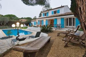 a backyard with a wooden bench and a house at Villa Provençal StTropez Ramatuelle Pampelonne beach in Saint-Tropez