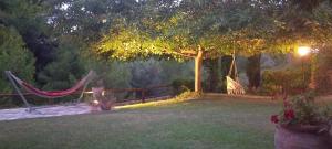 a hammock in a yard with a tree and a fence at Kalendes in Kalandra