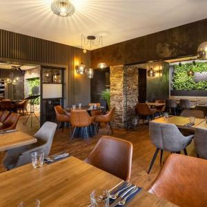 a restaurant with tables and chairs in a room at GARDEN Restaurant & Pension in Pardubice