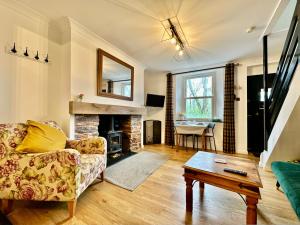 uma sala de estar com um sofá e uma lareira em Cosy cottage with character. em Brixham
