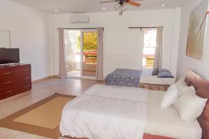 - une chambre avec un lit et une télévision dans l'établissement Las Palmas Beach Hotel, à Dixon Cove