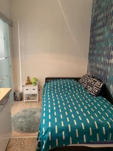 ein Schlafzimmer mit einem Bett mit einer grünen Bettdecke in der Unterkunft Single Sunny Mini Studio Flat in Budapest