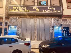 un'auto bianca parcheggiata di fronte all'edificio azzurro del cielo adhaka di Dakhla sky blue a Dakhla
