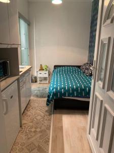 ein kleines Schlafzimmer mit einem Bett mit grüner Decke in der Unterkunft Single Sunny Mini Studio Flat in Budapest