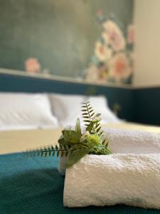 een stapel handdoeken en bloemen op een bed bij Blom apartments in Pisa