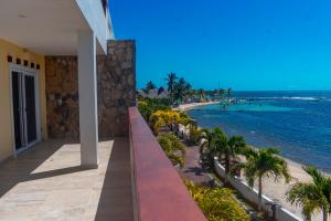 balcone con vista sulla spiaggia di un resort di Las Palmas Beach Hotel a Dixon Cove