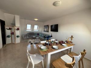 a living room with a table and white chairs at PANTELI APART HOUSE in Aheloy
