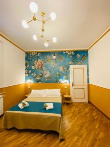 a bedroom with a large bed with a blue wall at Blom apartments in Pisa