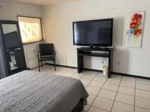 a bedroom with a bed and a flat screen tv at Departamento privado con cochera y WIFI alta velocidad in Chihuahua
