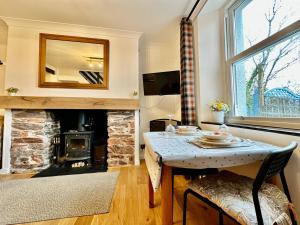 sala de estar con mesa y chimenea en Cosy cottage with character., en Brixham