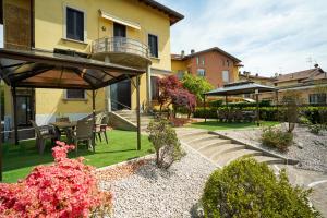 un giardino con tavolo, sedie e ombrellone di [Dalia Suite] Leonardo Academy, MXP & Lakes a Sesto Calende