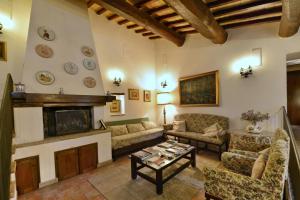 sala de estar con sofá y chimenea en Agriturismo Sasso Rosso en Capodacqua