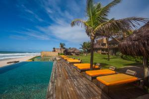una fila di sedie a sdraio e la spiaggia di Kenoa Exclusive Beach Spa & Resort a Barra de São Miguel