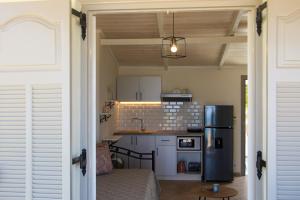 a kitchen with white cabinets and a black refrigerator at Garden Studios in Alykes