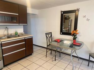 a kitchen with a table and a sink and a mirror at Departamento privado con cochera y WIFI alta velocidad in Chihuahua