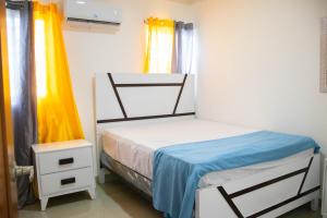 a small bedroom with a bed and two windows at 3 BR apartment ciudad santiago de los caballeros in Santiago de los Caballeros