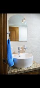 a bathroom sink with a blue towel and a mirror at 3 BR apartment ciudad santiago de los caballeros in Santiago de los Caballeros