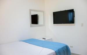 Schlafzimmer mit einem Bett und einem Flachbild-TV in der Unterkunft 3 BR apartment ciudad santiago de los caballeros in Santiago de los Caballeros