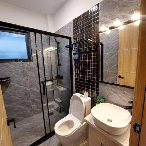 een badkamer met een douche, een toilet en een wastafel bij Lovely 1 bedroom, Staroot Residency in Nairobi