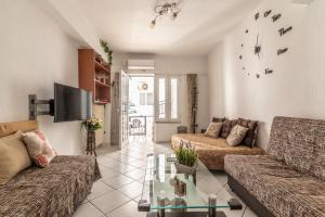 un soggiorno con 2 divani e una TV di FrontYard Flat near the Beach a Heraklion