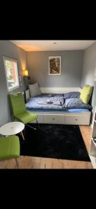 a small bedroom with a bed and a green chair at Tiny-Ferienwohnung Hellerau 2 in Dresden