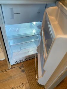 um frigorífico vazio com a porta aberta numa cozinha em Tiny-Ferienwohnung Hellerau 2 em Dresden