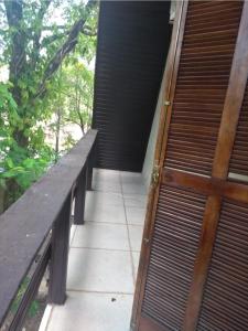 a porch with a wooden bench and a door at Vila Chale in Bauru