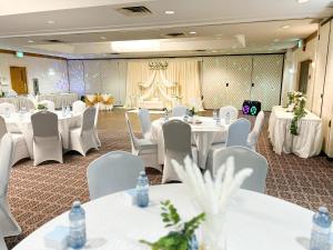 a banquet hall with white tables and white chairs at Ramada by Wyndham London in London