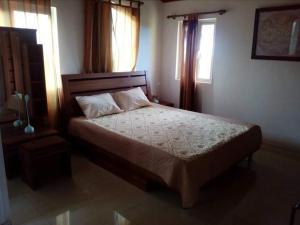 a bedroom with a bed and two windows at Sur la route des tortues in Rodrigues Island