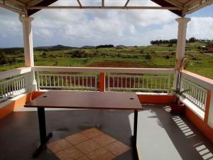 a bench on a porch with a view of a field at Sur la route des tortues in Rodrigues Island