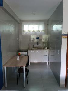 a small kitchen with a wooden table and a sink at Flats 3 Locação Penedo RJ in Penedo
