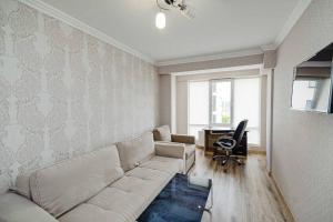 sala de estar con sofá y escritorio en Apartament cu vedere la parc, en Chişinău