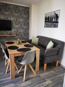 ein Wohnzimmer mit einem Tisch und einem Sofa in der Unterkunft Ferienhaus Thalia 1 in Übach-Palenberg