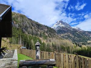 a wooden fence with a mountain in the background at Siegel Almhütte in Zederhaus
