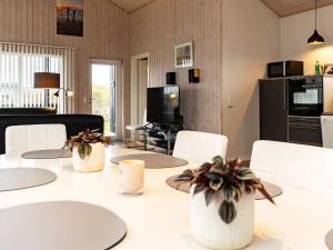 a dining room with white tables and white chairs at 6 person holiday home in Hirtshals in Hirtshals