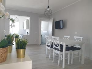 un comedor blanco con una mesa y sillas blancas en Mare e Vacanze, en Villa San Pietro