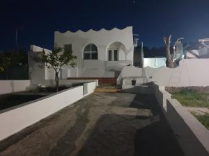 Una casa blanca con un árbol delante. en Mare e Vacanze, en Villa San Pietro