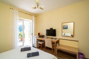 a bedroom with a desk and a computer and a mirror at Rooms and Apartment Nike in Dubrovnik