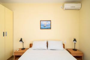 1 dormitorio con 1 cama blanca y 2 lámparas en Rooms and Apartment Nike en Dubrovnik