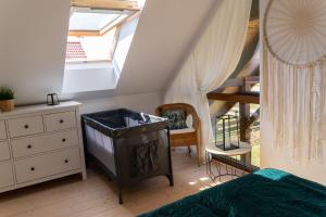 sypialnia z łóżkiem, komodą i schodami w obiekcie Rozmaryn - Komfortowy domek całoroczny na Kaszubach w mieście Borowy Młyn