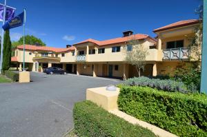 a building with a car parked in a parking lot at Tuscany Gardens Motor Lodge in Nelson