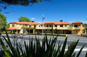 a building with a flag in front of a street at Tuscany Gardens Motor Lodge in Nelson