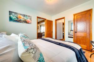 - une chambre avec un lit blanc et une porte en bois dans l'établissement Charming Eagle Grove Farmhouse with Patio!, à Eagle Grove