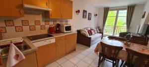 a kitchen with a microwave and a table and a couch at Le Petit Nid in Bergheim